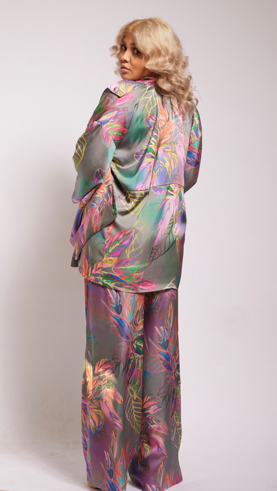 Back profile of woman wearing all over tropical printed kimono duster and matching yacht pants made from recycled materials