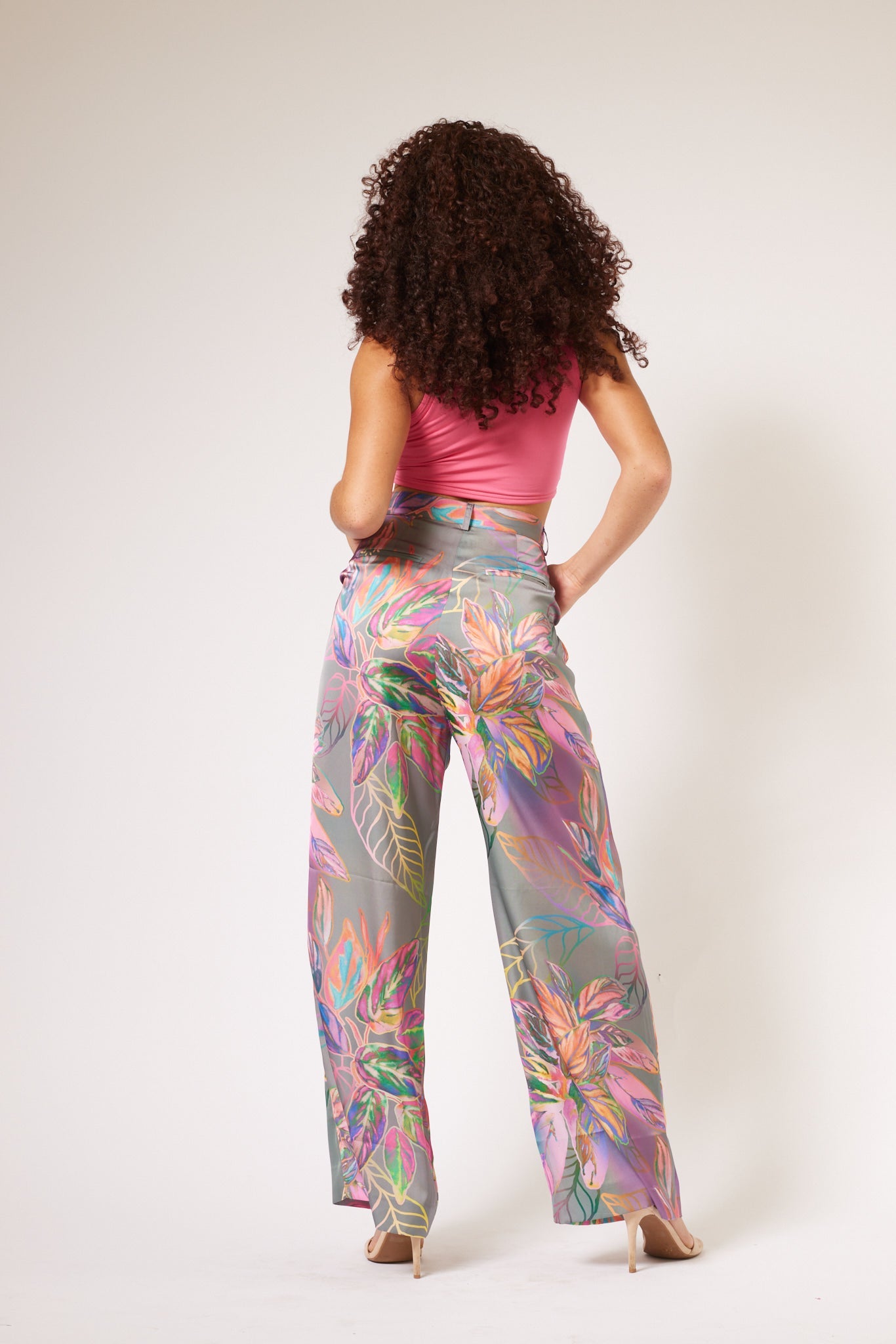 back view of woman modelling all over multicolored tropical yacht pants made from recycled materials