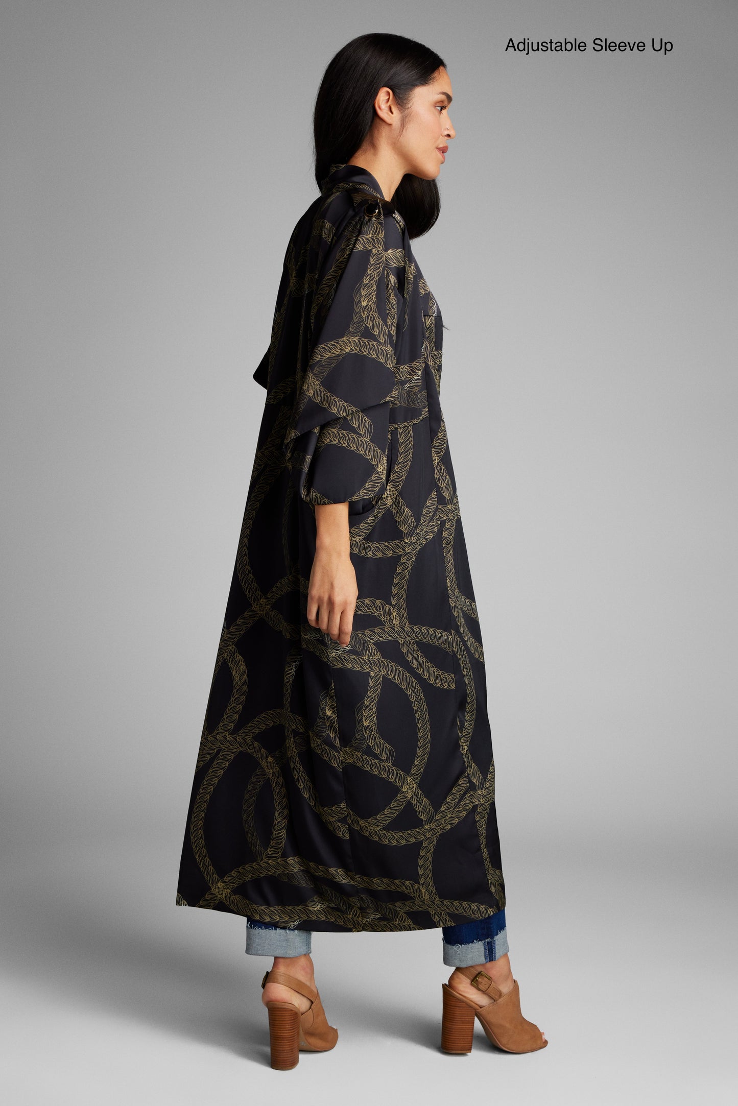 Side profile of woman wearing a black and gold chain print kimono duster made from recycled materials