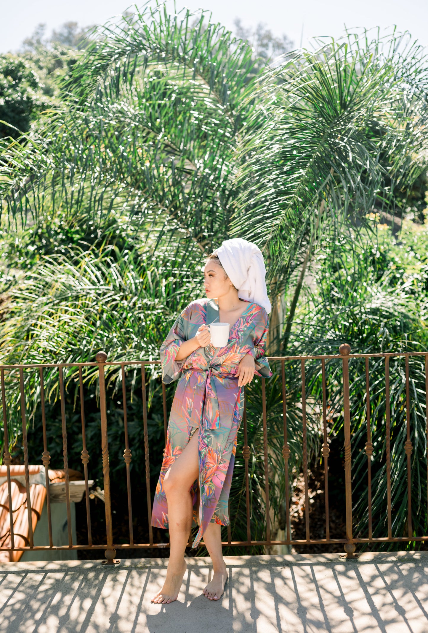 Woman wearing kimono robe in Carmen outside leaning on gate