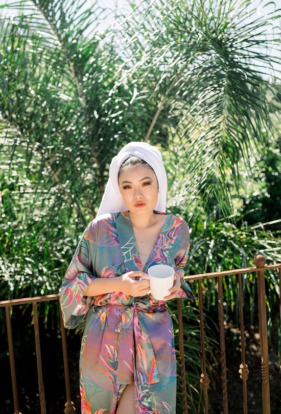 Woman wearing kimono robe in Carmen standing outside holding a mug