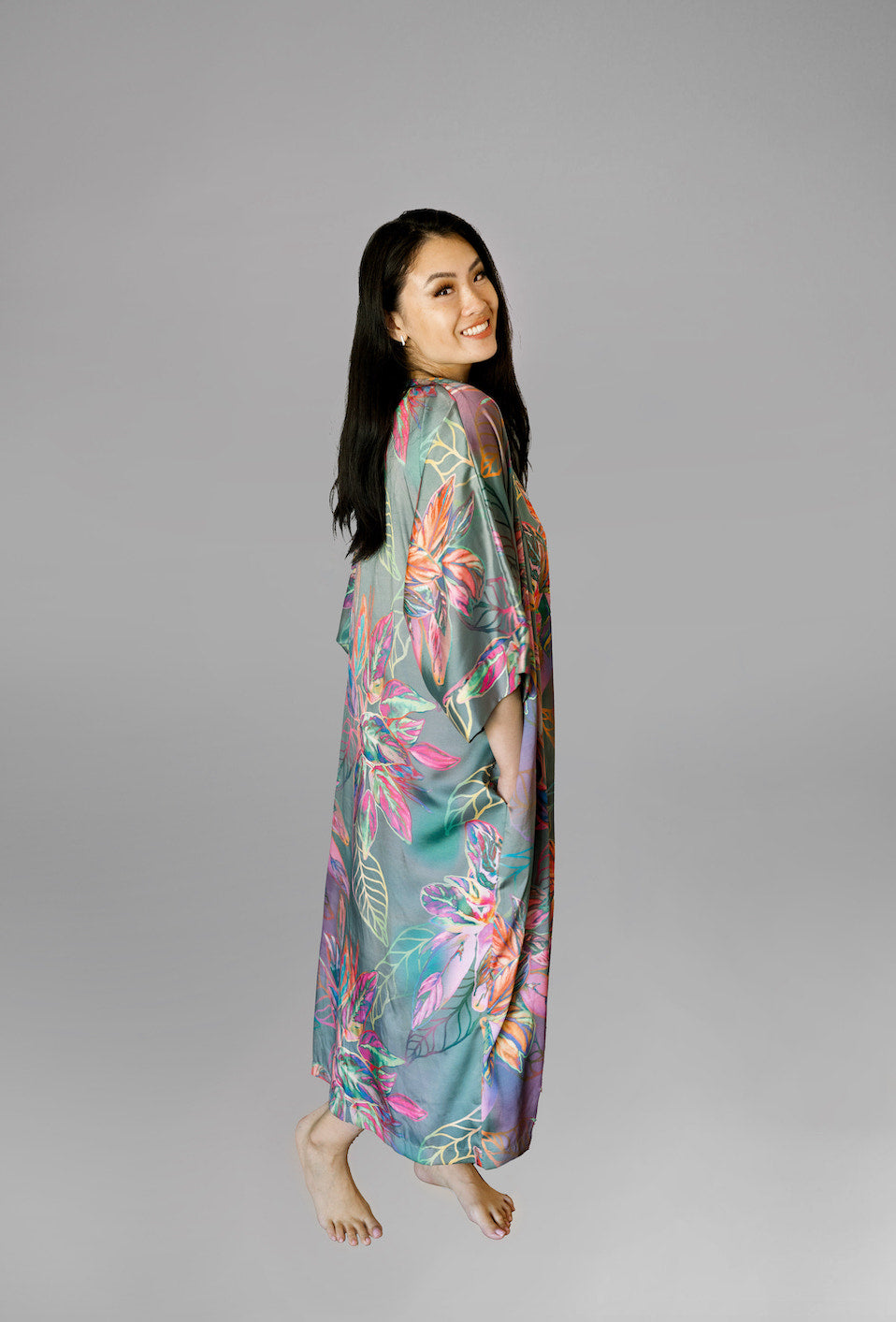 Woman wearing kimono robe in Carmen back profile view with hands at her side