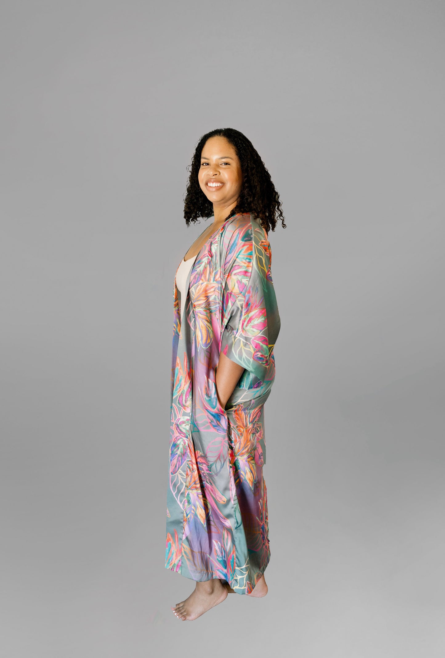 Woman wearing kimono robe in Carmen front profile view robe open hand in her pocket