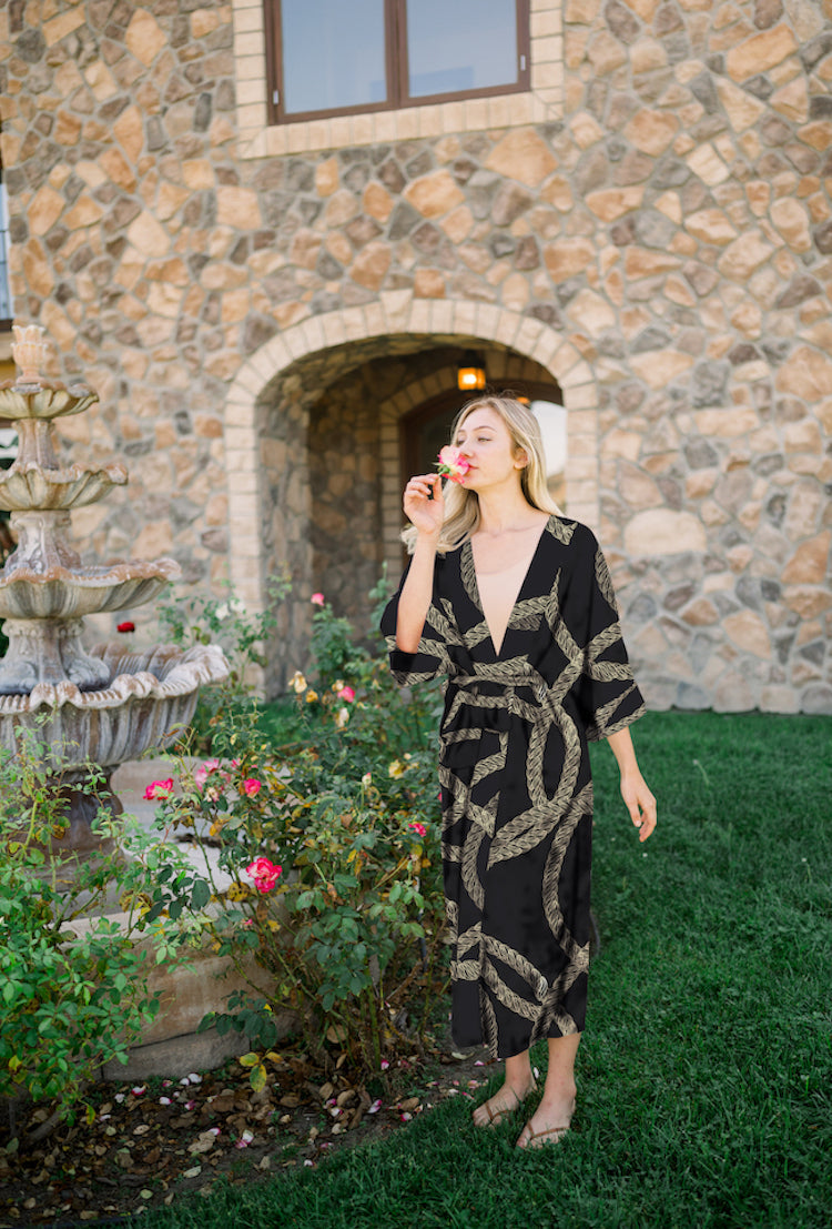 Woman wearing kimono robe in Justine outside next to flower garden