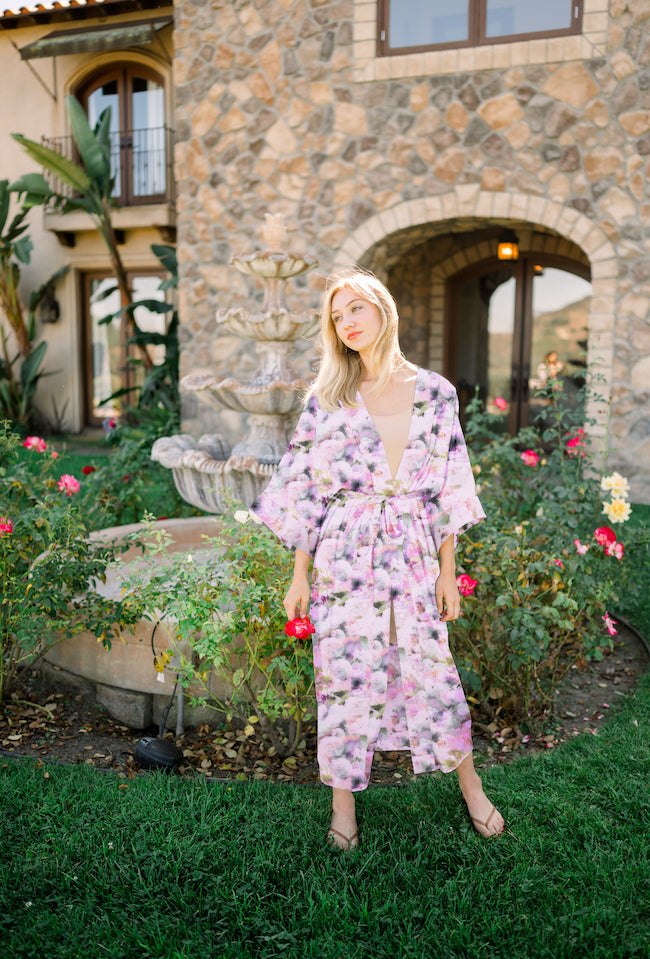 Woman wearing kimono robe in Pink Poppy standing outside near flower garden