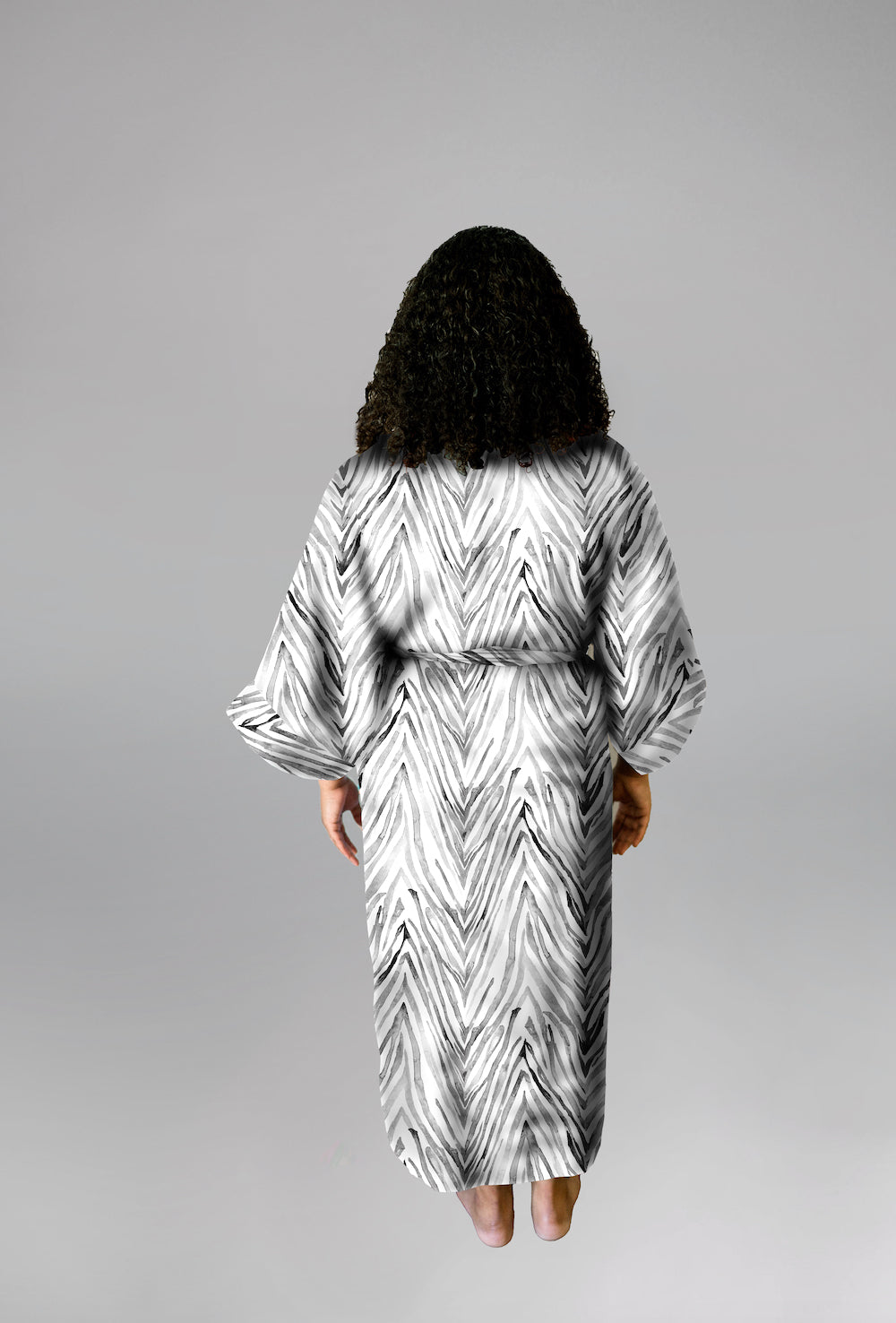 Woman wearing kimono robe in Zebra back profile view with hands at her side