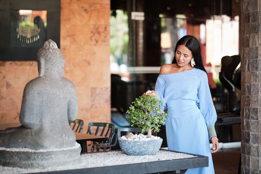 woman outside patio wearing lavender kaftan duster with embroidered sleeves made from recycled materials 2