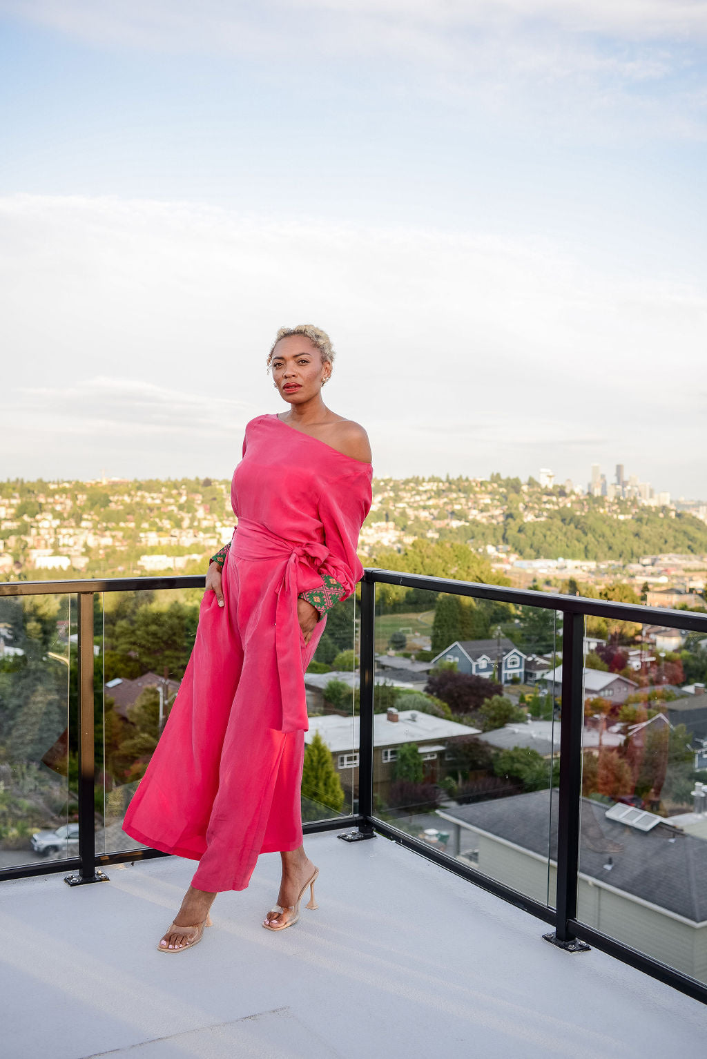 woman modelling outside wearing a magenta kaftan duster with embroidered sleeves made from recycled materials