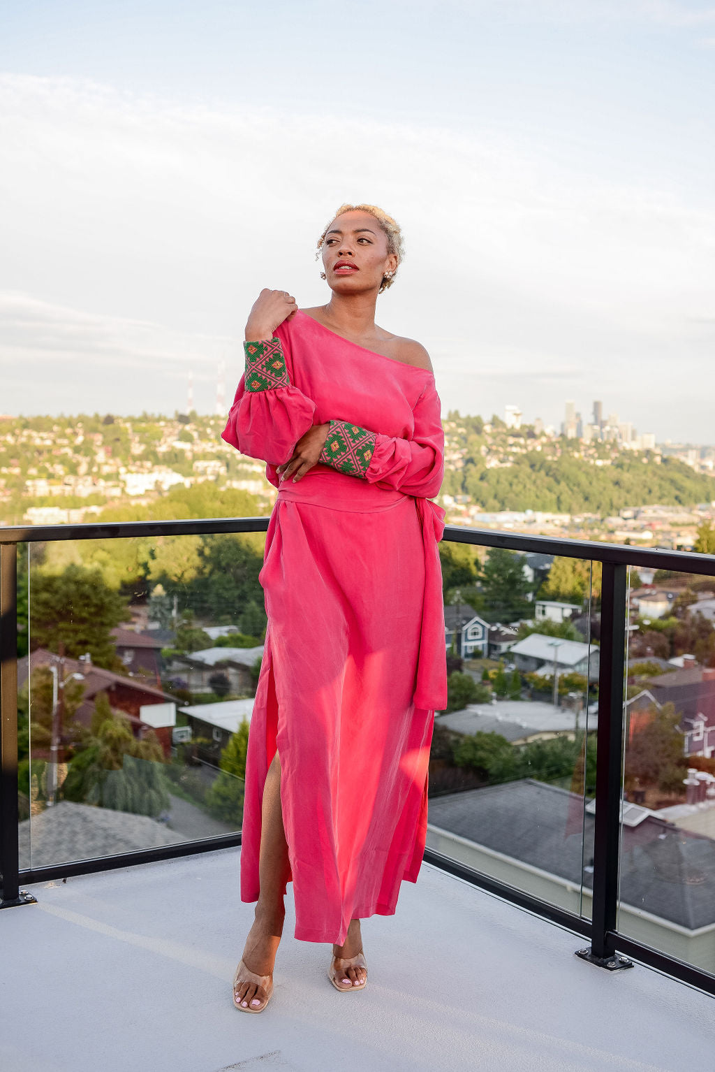 woman modelling outside wearing a magenta kaftan duster with embroidered sleeves made from recycled materials 2