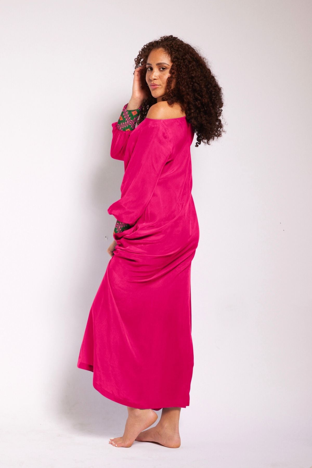 close up view of woman wearing a magenta kaftan duster with embroidered sleeves made from recycled materials 3