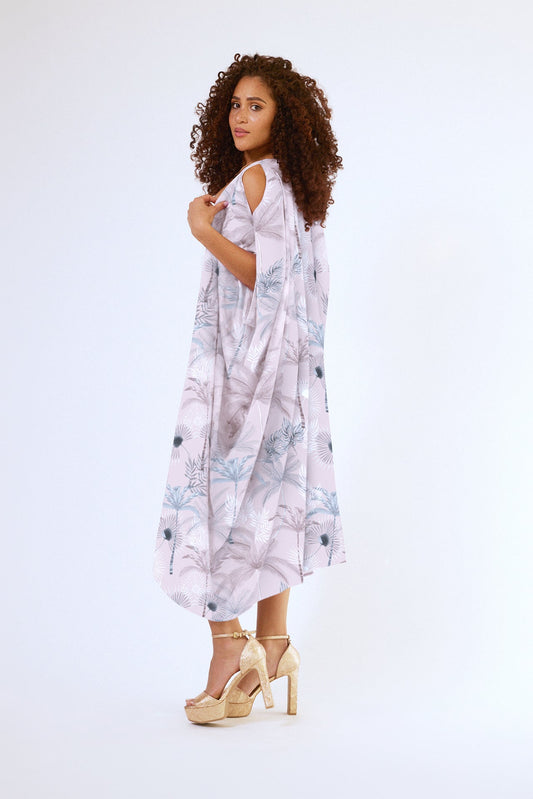 side view of woman wearing all over blush tropical print kaftan duster with front zipper made from recycled materials