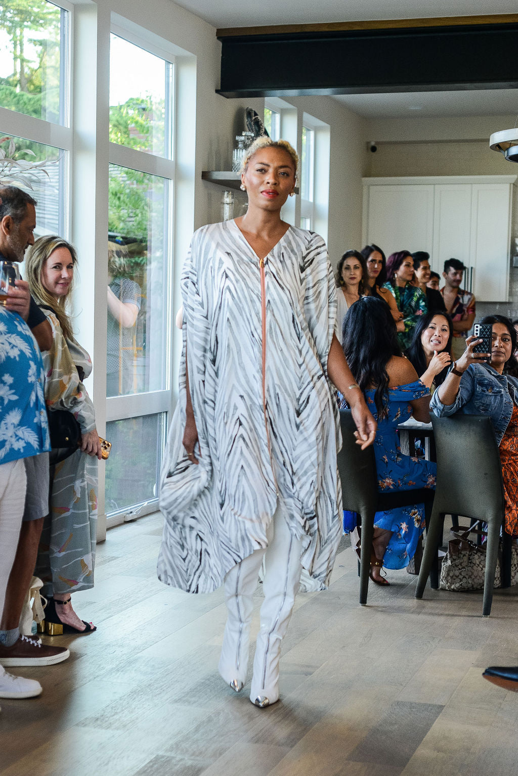 woman runway modelling wearing an all over grey zebra print kaftan duster with zipper made from recycled materials