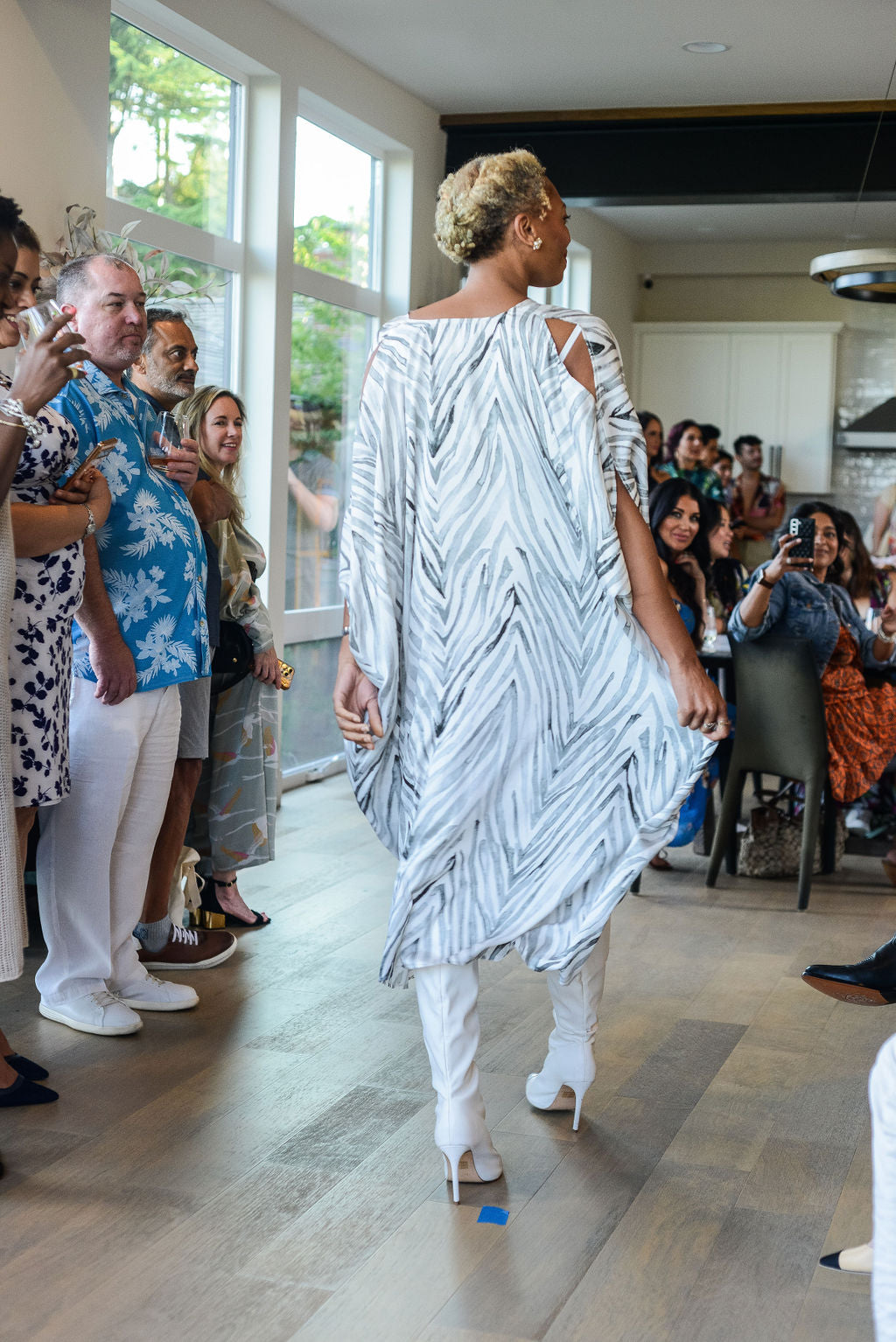 woman runway modelling wearing an all over grey zebra print kaftan duster with zipper made from recycled materials 2