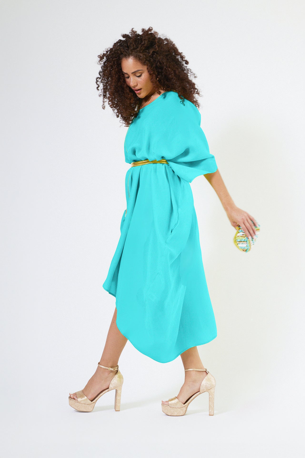 side view of woman wearing bright turquoise kaftan duster with front zipper made from recycled materials
