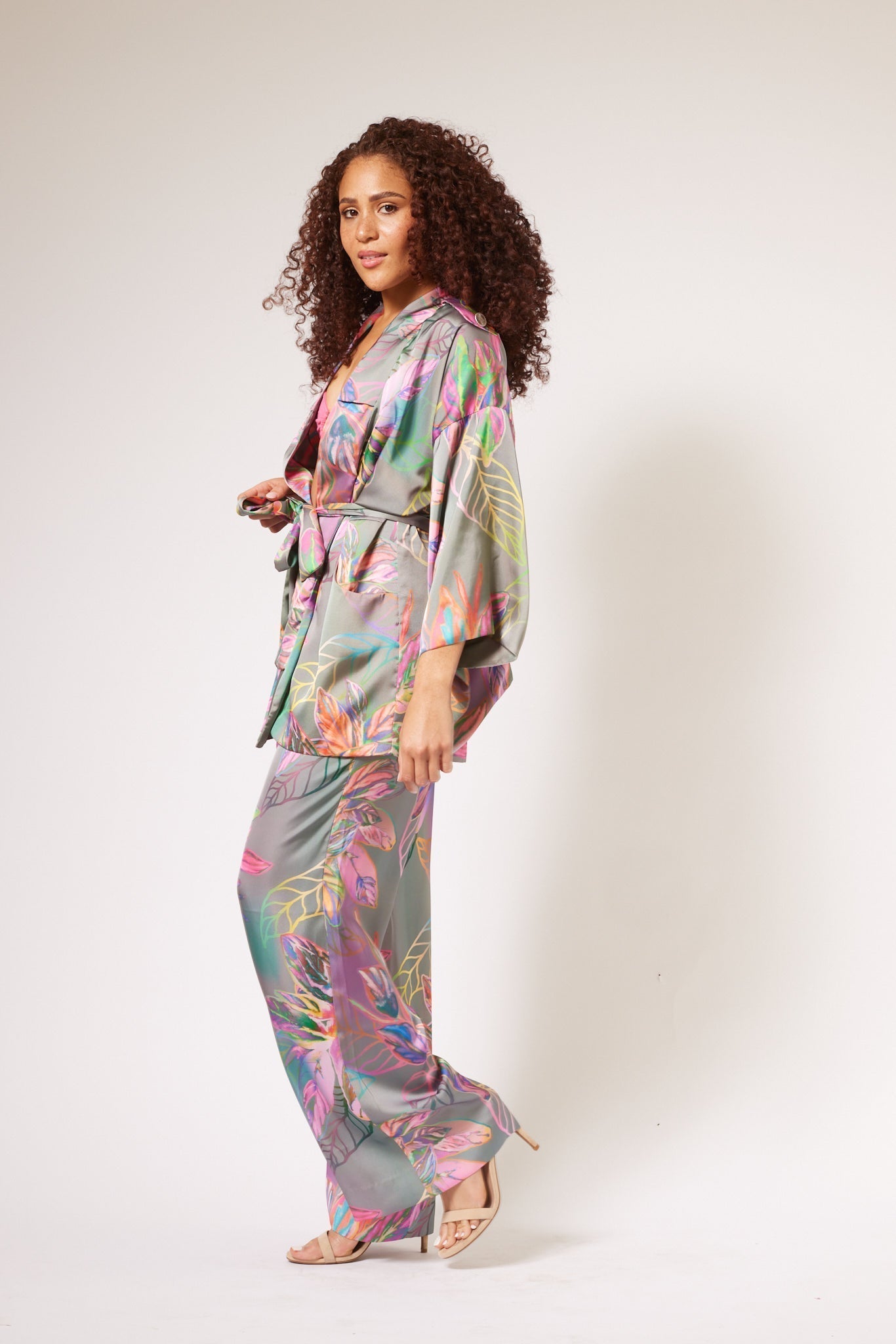side profile of woman modelling all over multicolored tropical print kimono duster and matching yacht slacks made with recycled textiles