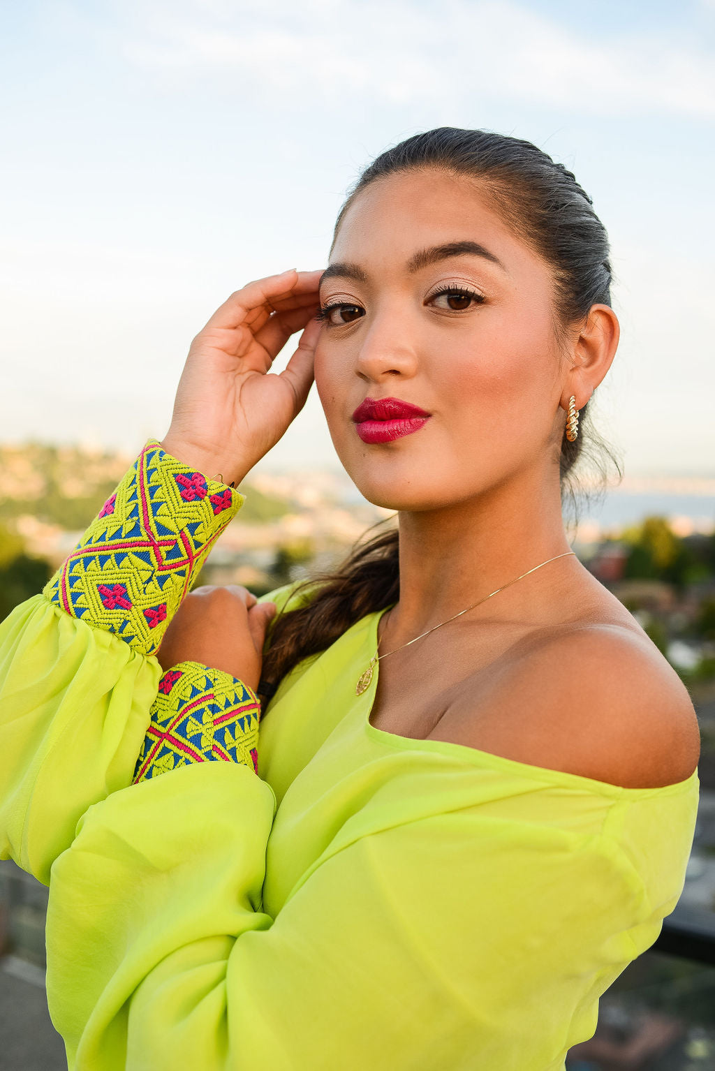 close up view of woman modelling a bright yellow kaftan duster with embroidered sleeves made from recycled materials 7