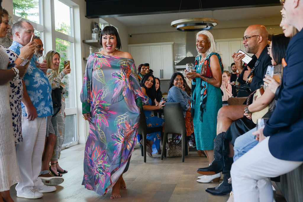 woman modelling an all over tropical printed kaftan duster with embroided cuffs made from recycled materials 2