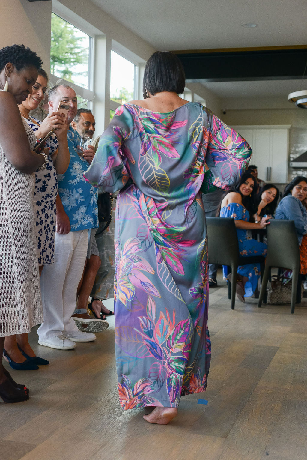 woman modelling an all over tropical printed kaftan duster with embroided cuffs made from recycled materials 2