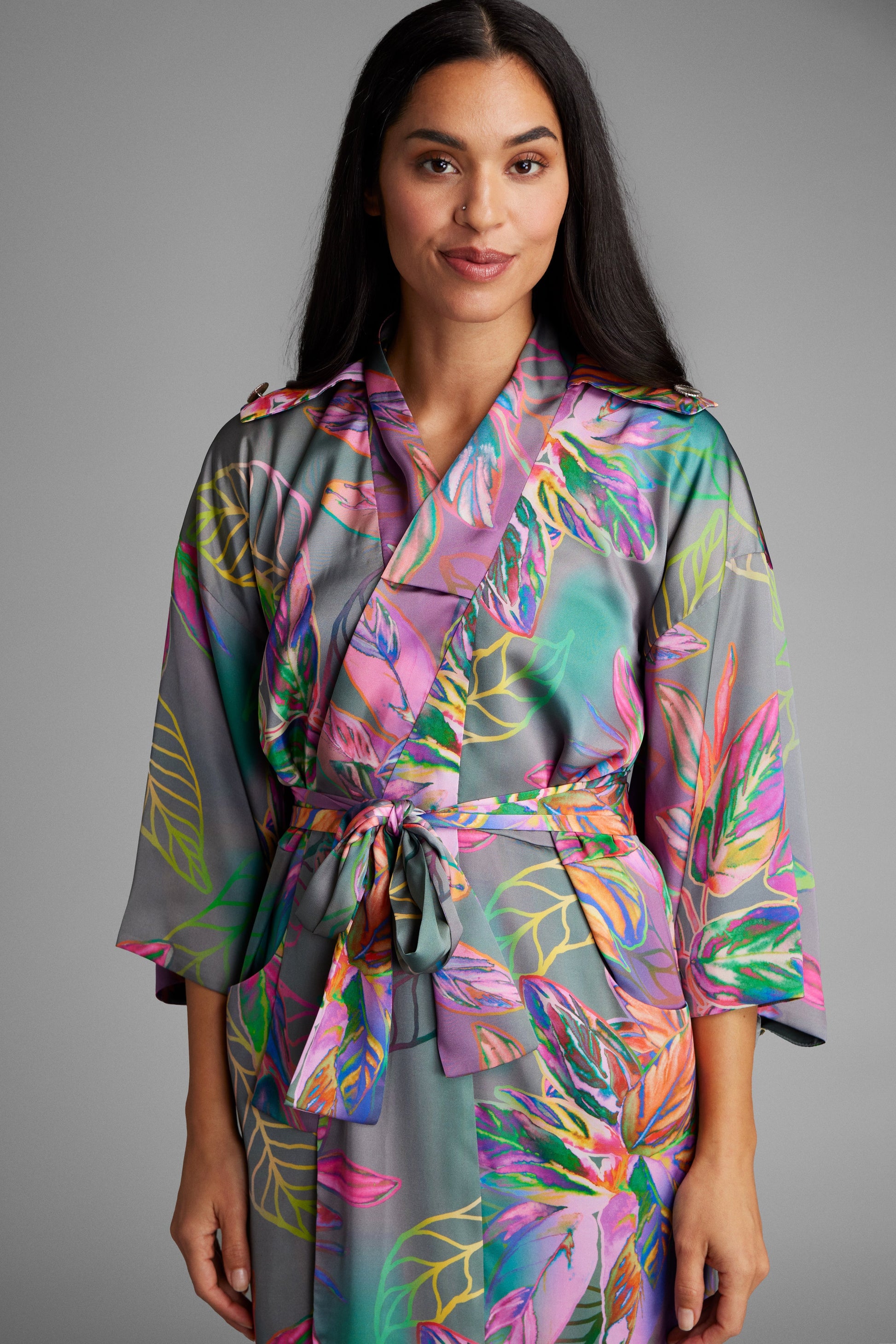 Woman standing with hands at her side wearing an all over tropical printed kimono duster made from recycled materials