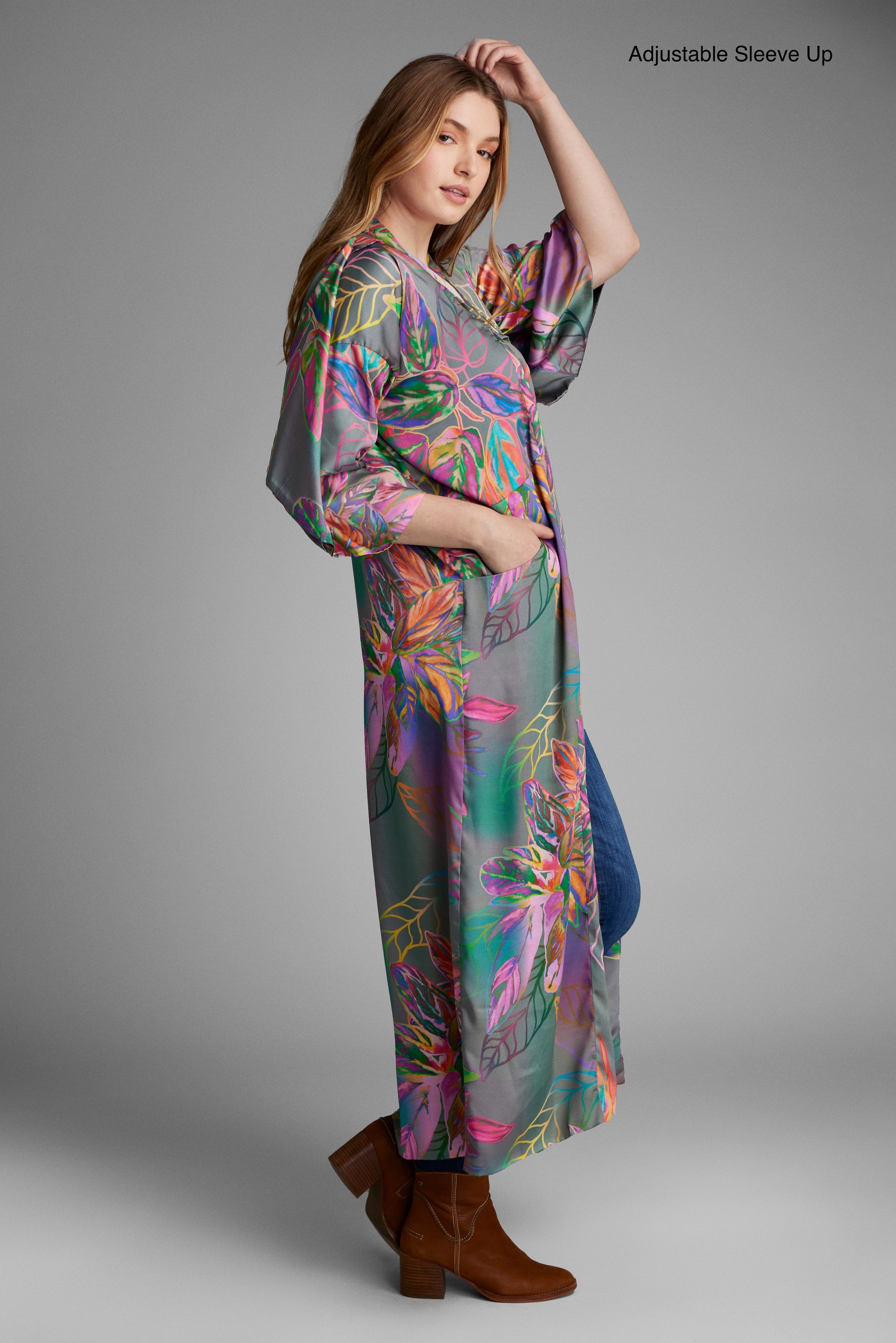 Woman standing with hand in pocket wearing an all over tropical print kimono duster made from recycled materials 4