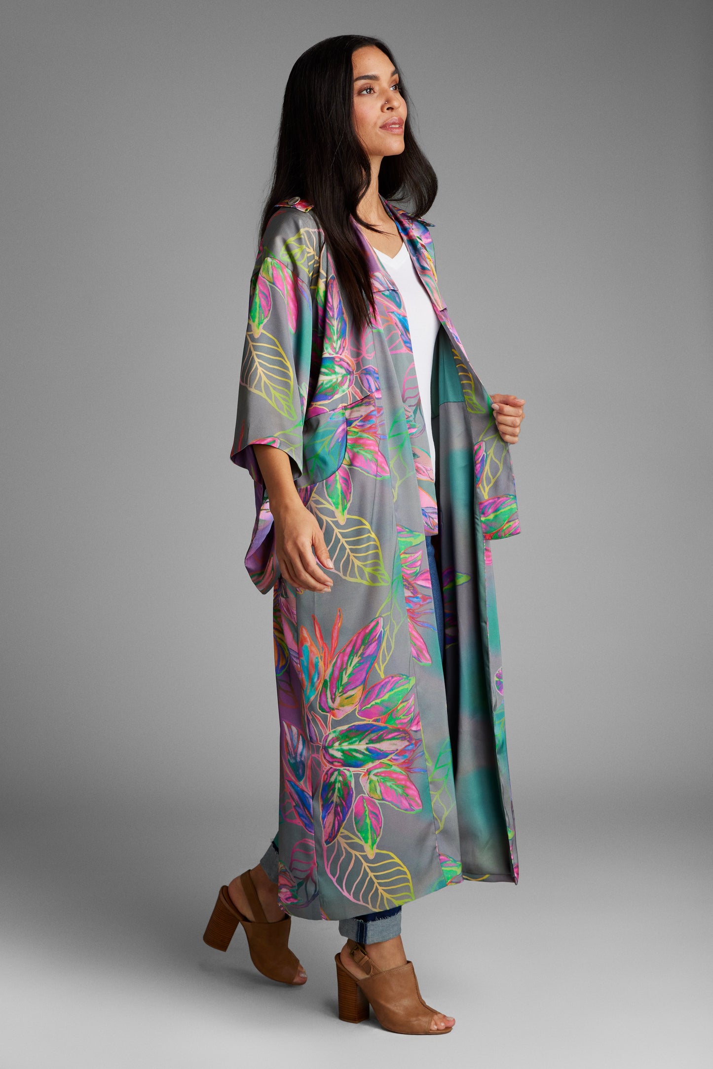 Woman standing wearing an all over tropical printed kimono duster made from recycled materials 2