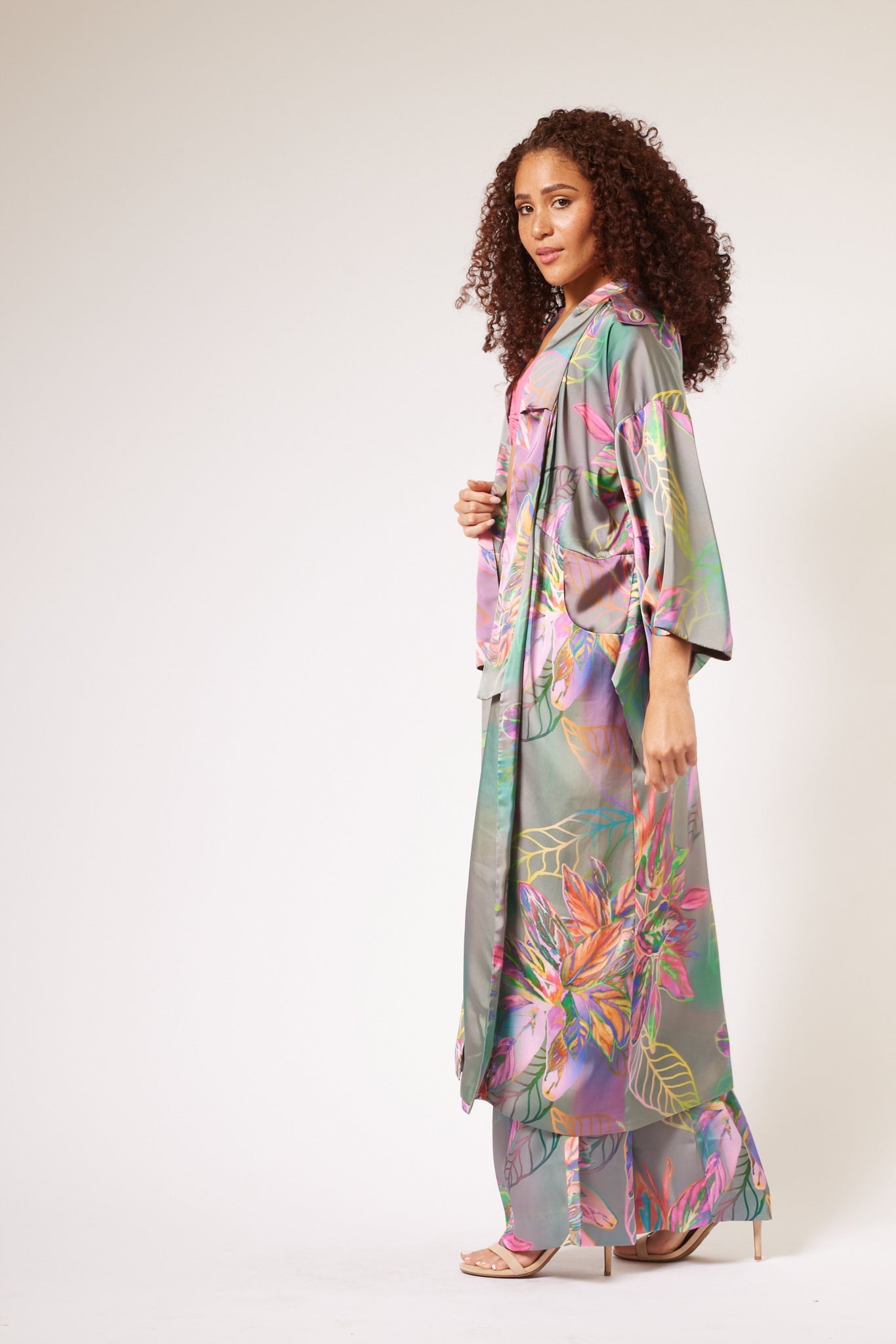 side profile of woman modelling all over multicolored tropical print kimono duster and matching yacht slacks made with recycled textiles 2