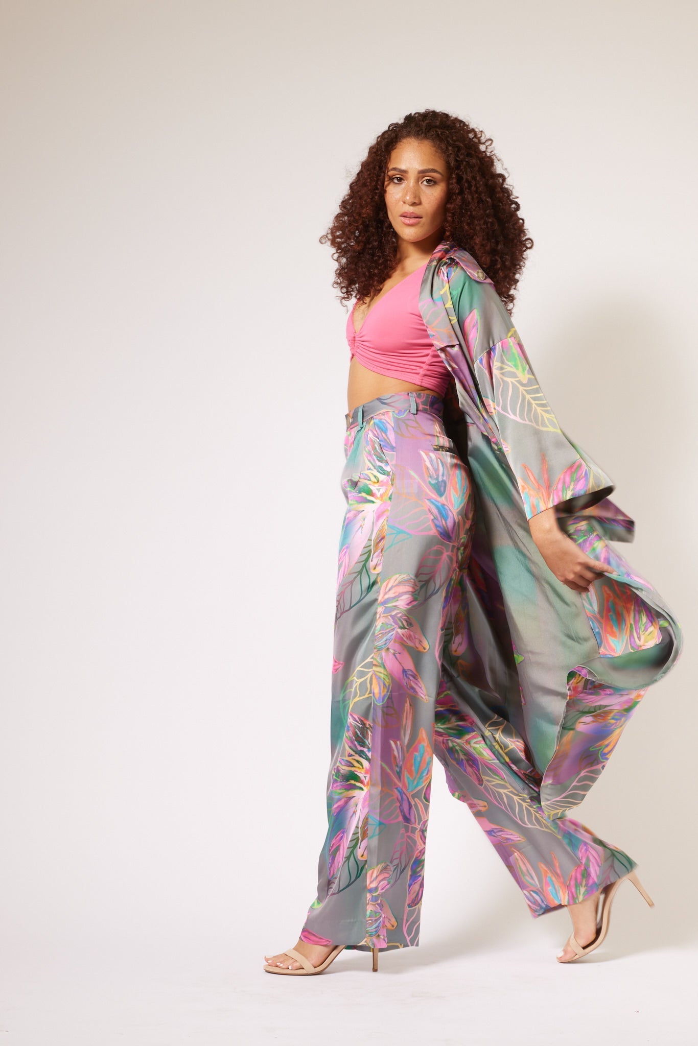 side profile of woman modelling all over multicolored tropical print kimono duster and matching yacht slacks made with recycled textiles 3