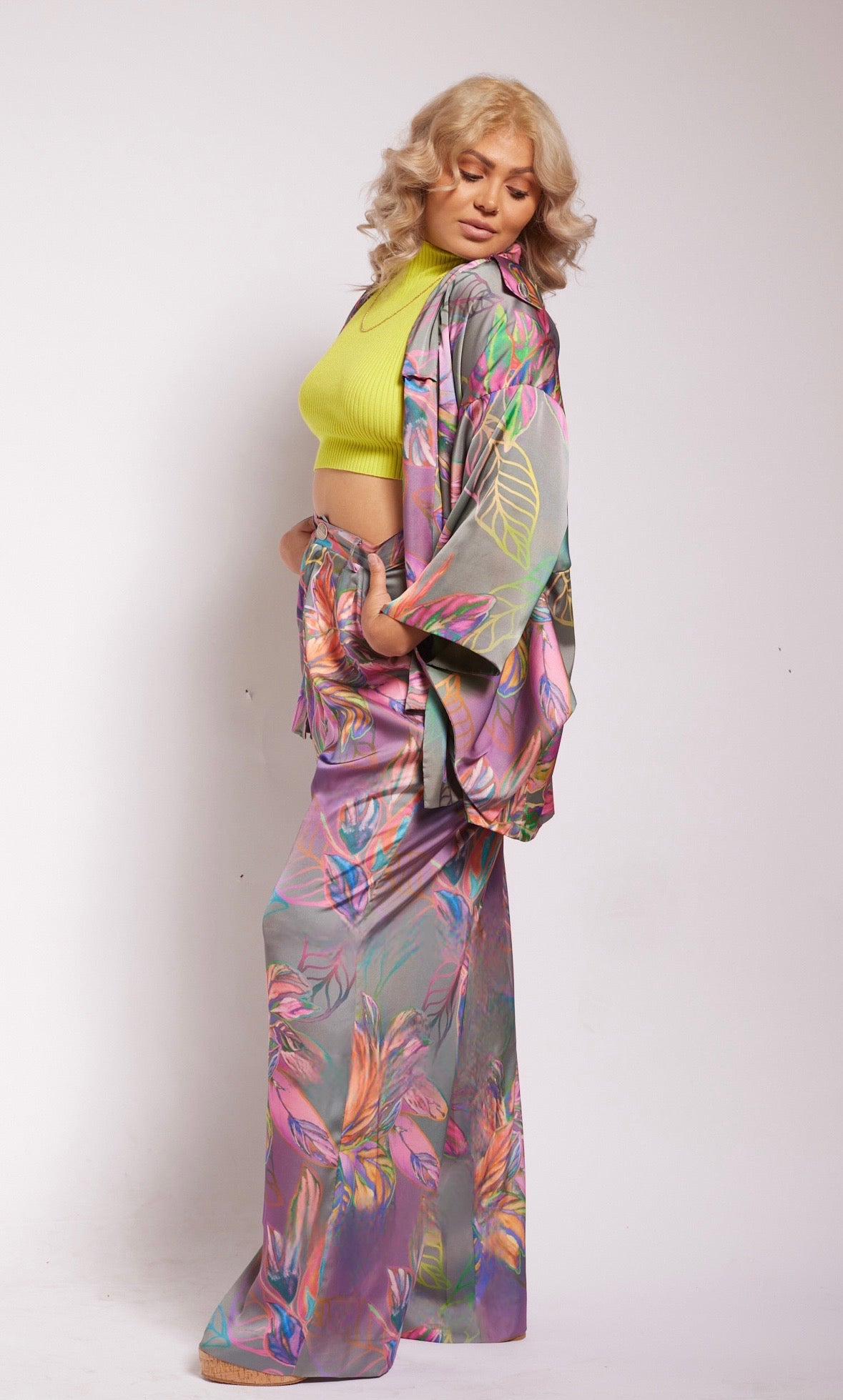 side profile of woman modelling all over multicolored tropical print kimono duster and matching yacht slacks made with recycled textiles 4