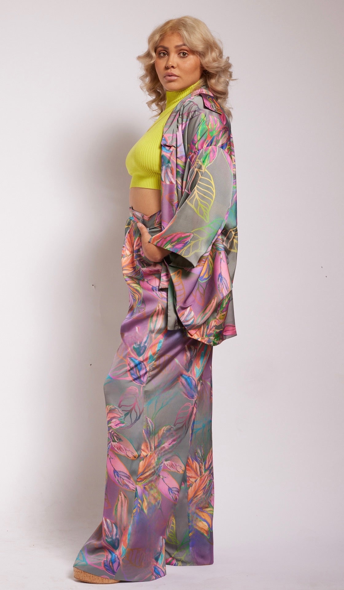 side profile of woman wearing all over multicolored tropical print yacht pants and yellow top 3