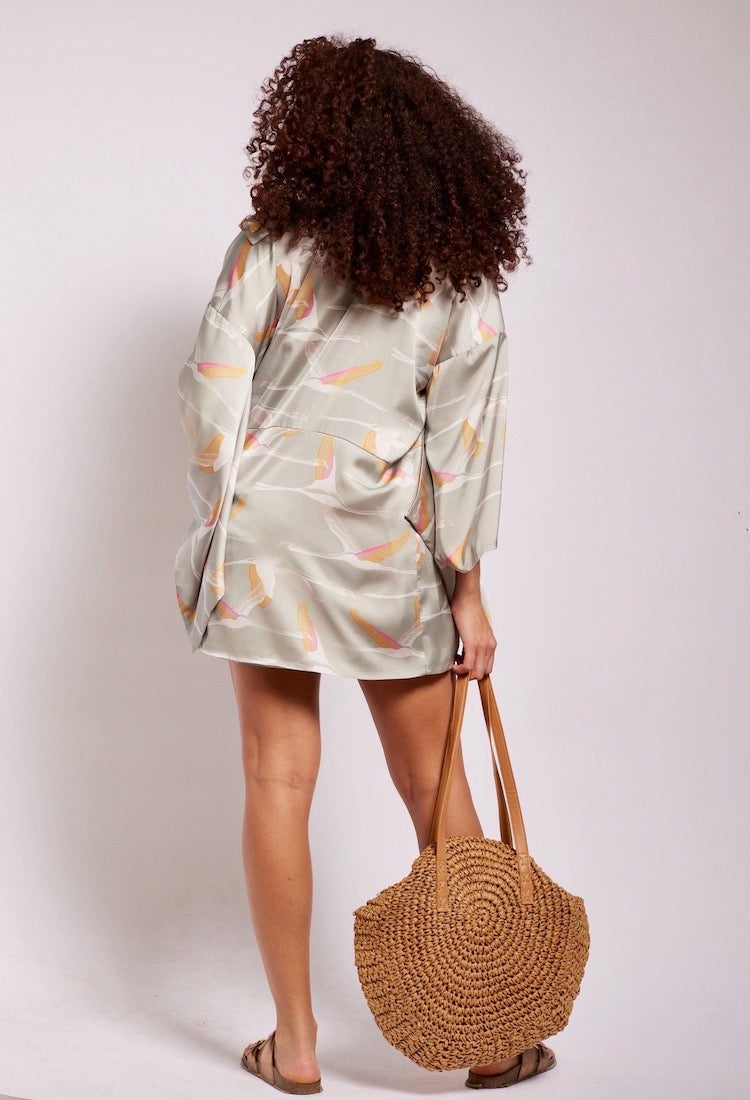 back view of woman wearing a grey pink and gold colored crane printed kimono duster made from recycled materials 2