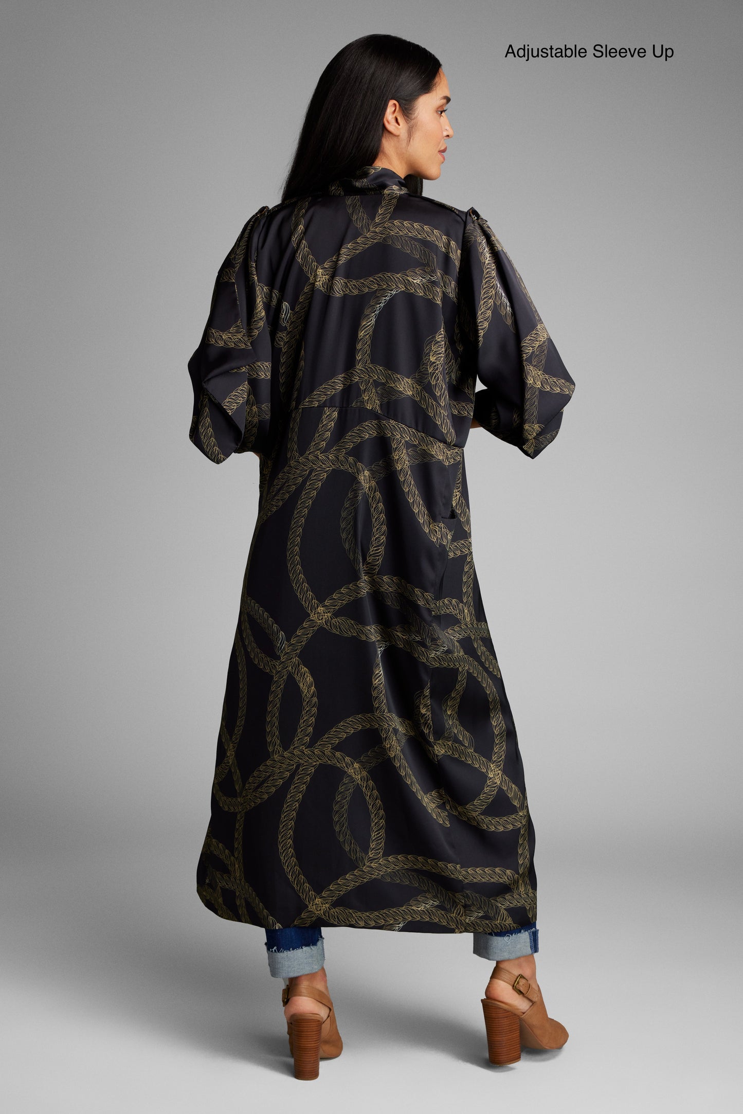Woman showing her back wearing a black and gold chain print kimono duster made from recycled materials 3