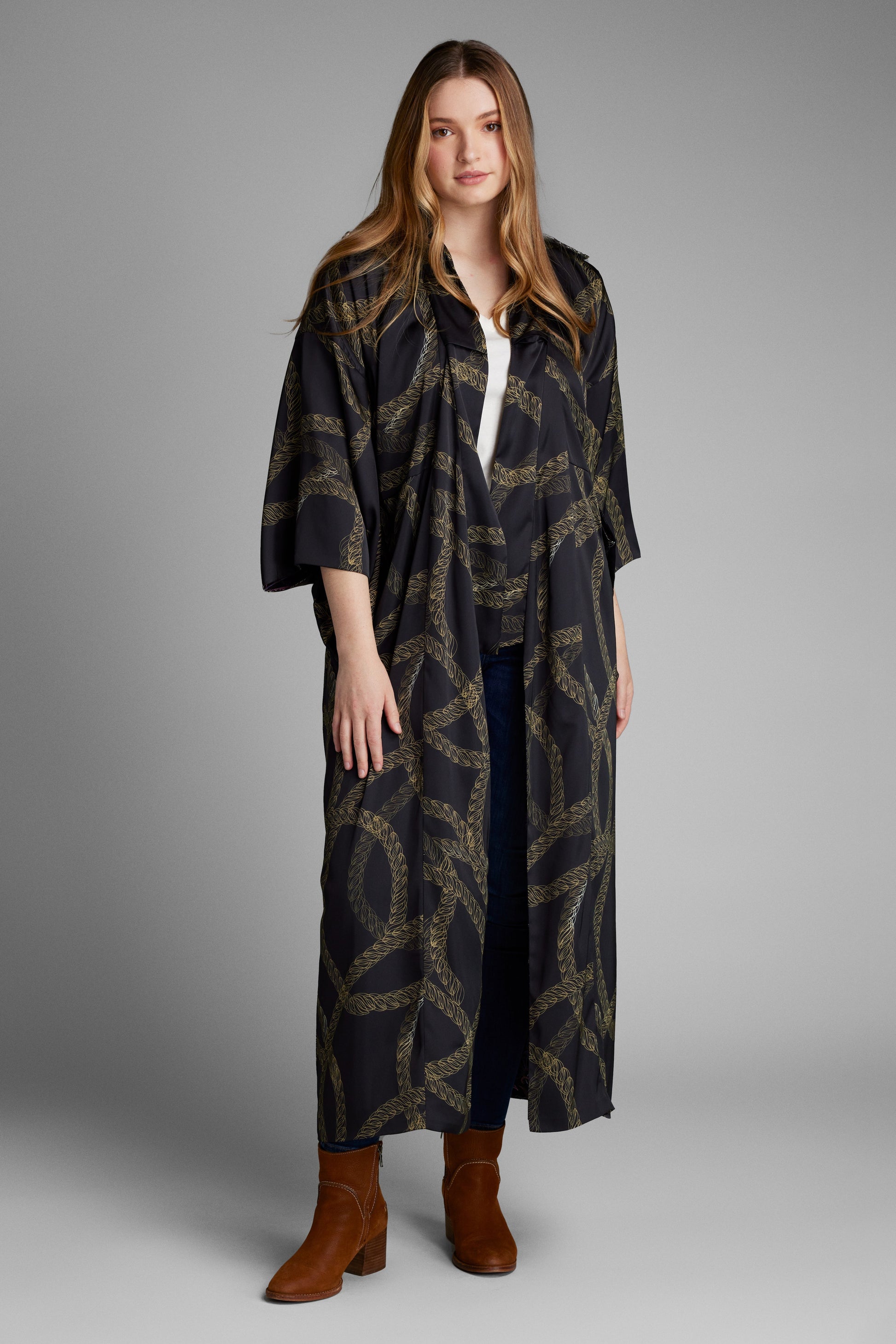 Side profile of woman wearing a black and gold chain print kimono duster made from recycled materials 3