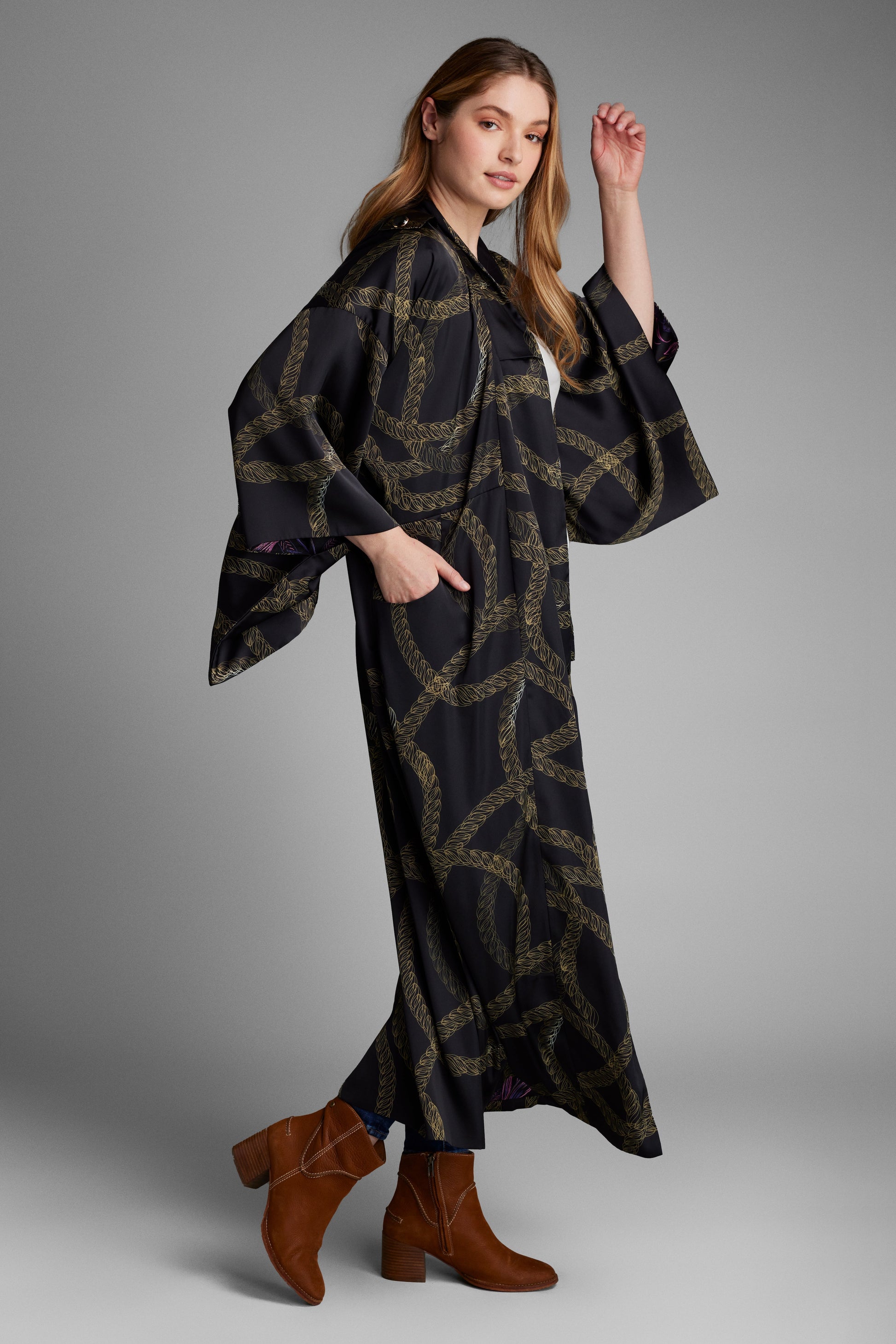 Women modelling a black and gold colored chain print kimono duster that has been made from recycled textiles
