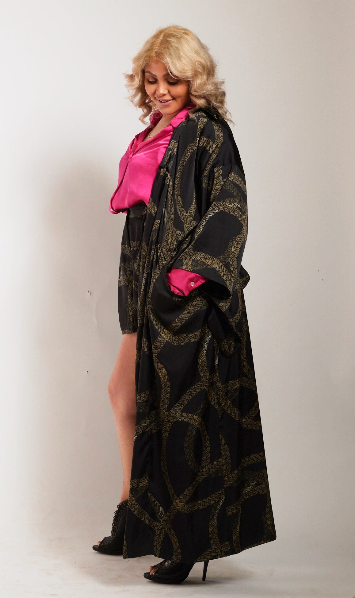 side profile of woman wearing gold and black chain printed tulip shorts and matching kimono duster made from recycled textiles