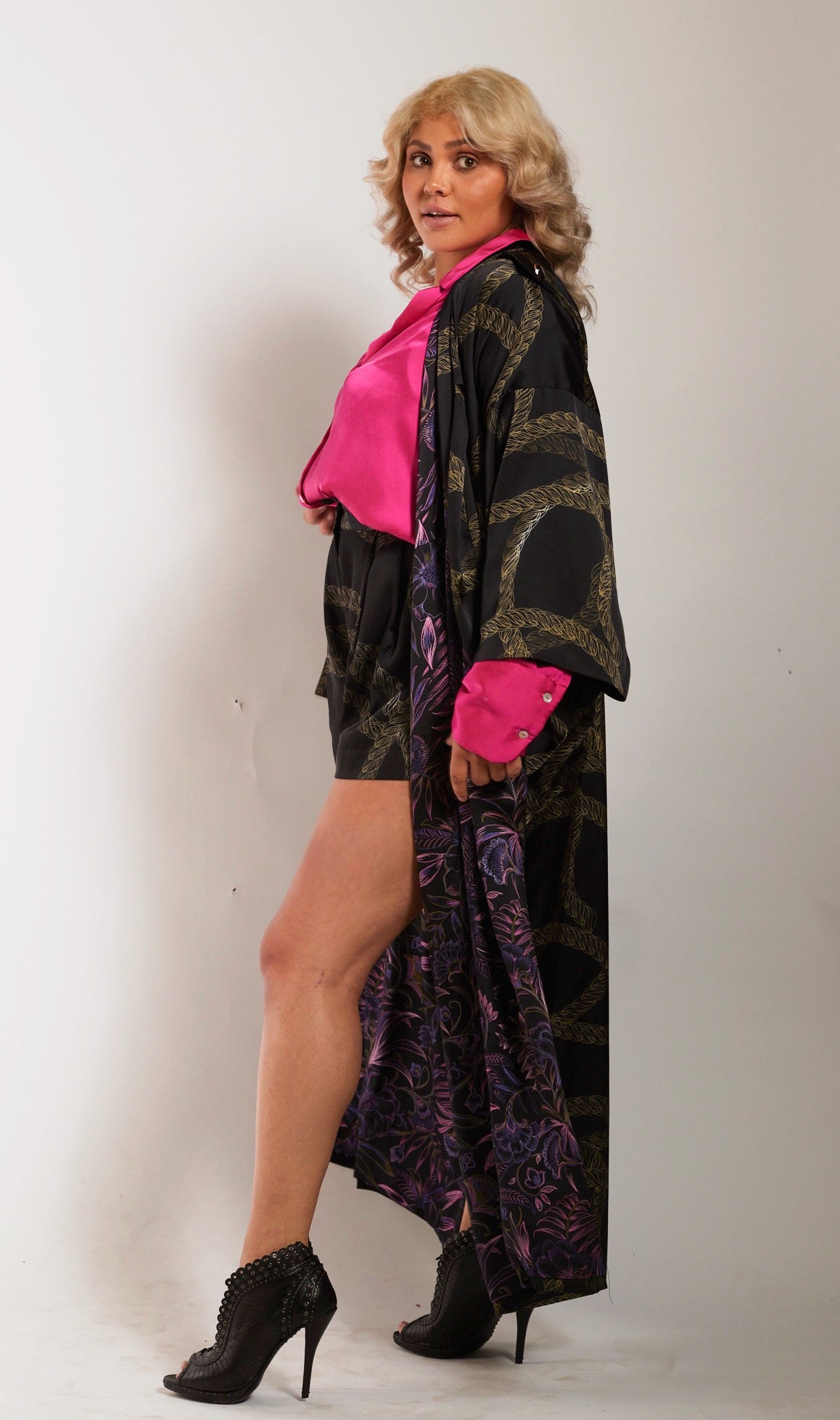 side profile of woman wearing gold and black chain printed tulip shorts and matching kimono duster made from recycled textiles 2