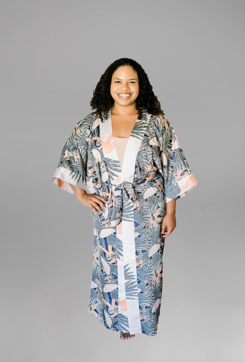 Woman wearing kimono robe in navy toucans with hand at her side