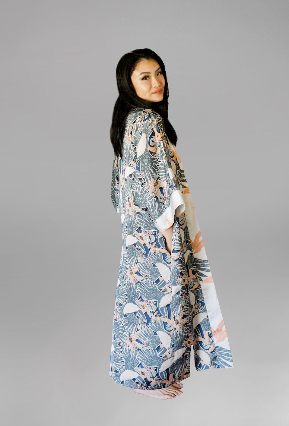 Woman wearing kimono robe in navy toucans back and side profile view