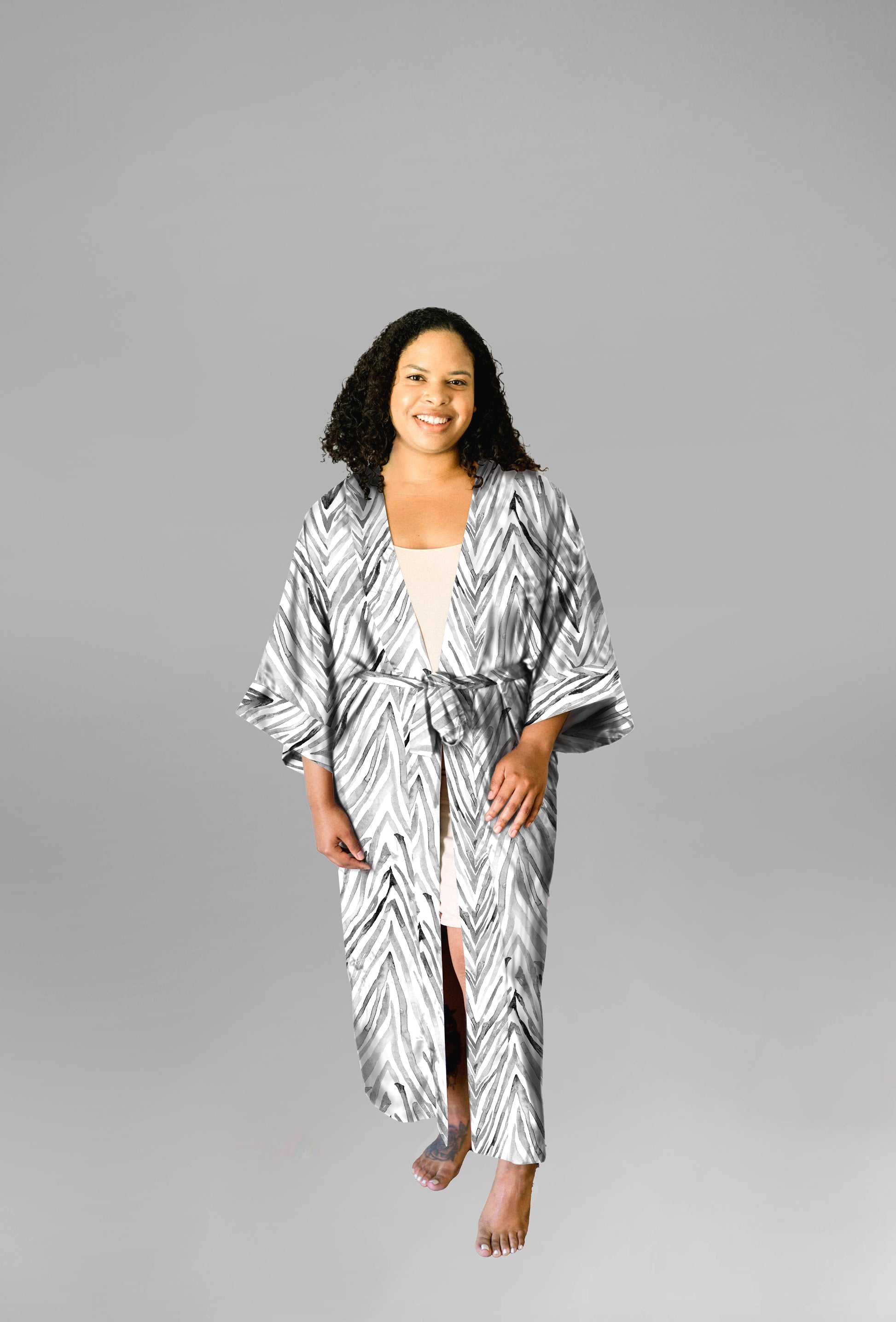 Woman wearing kimono robe in Zebra front profile view with one hand in her pocket