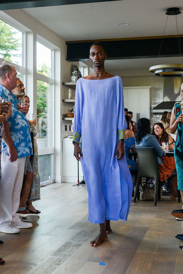 man modelling wearing lavender kaftan duster with embroidered sleeves made from recycled materials