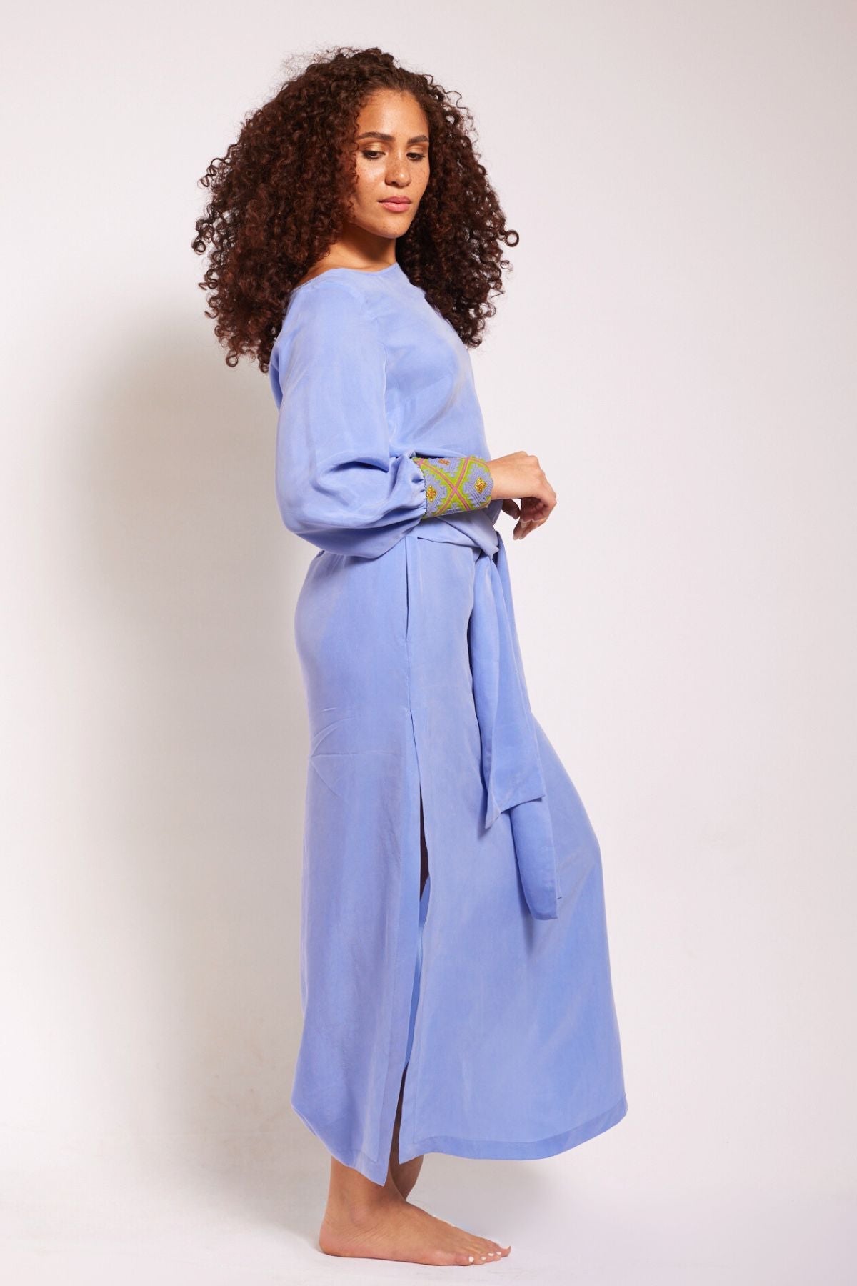 side view of woman wearing lavender kaftan duster with embroidered sleeves made from recycled materials