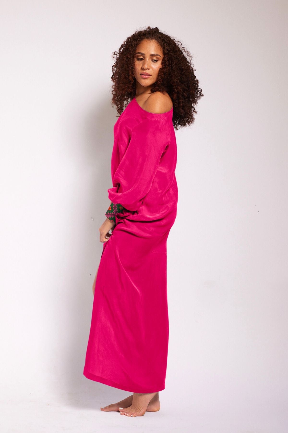 close up view of woman wearing a magenta kaftan duster with embroidered sleeves made from recycled materials 2