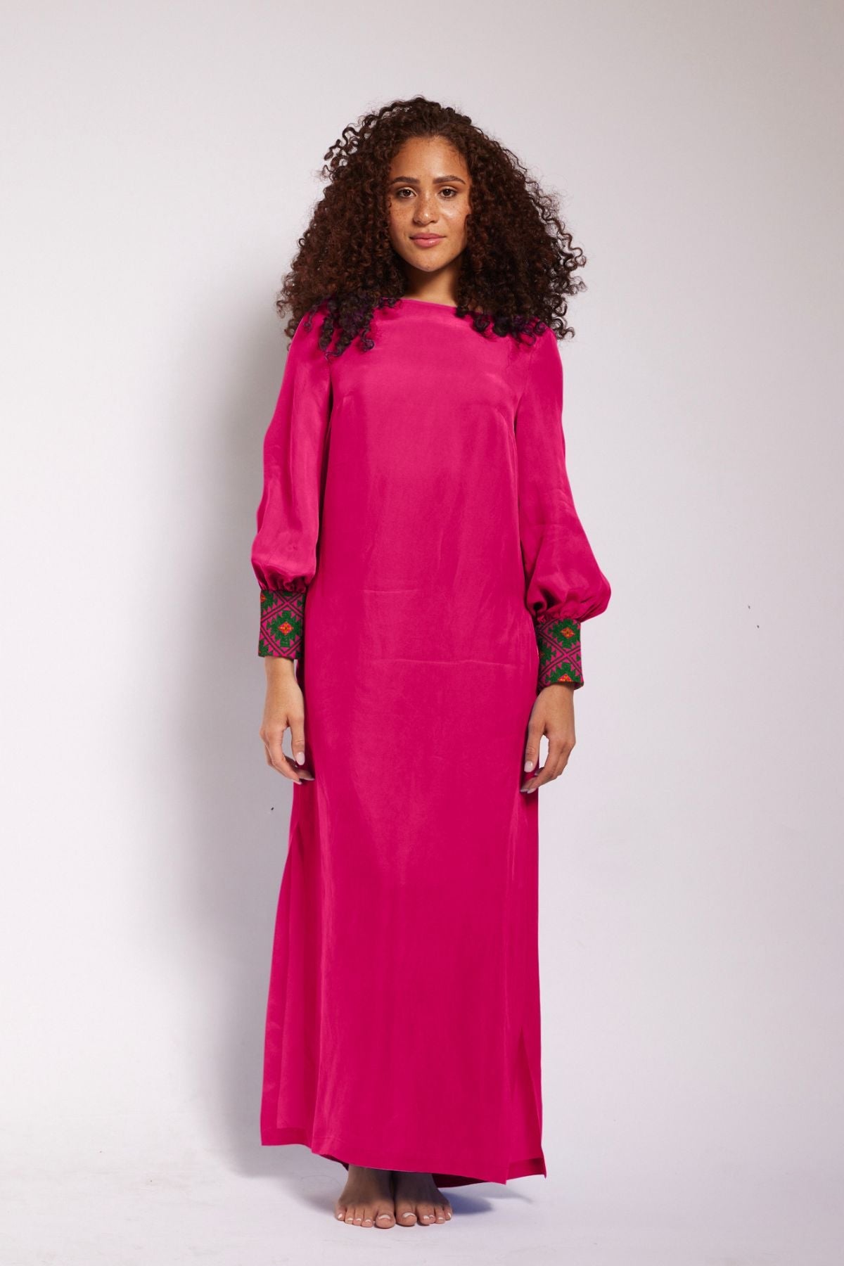 front profile view of woman wearing a magenta kaftan duster with embroidered sleeves made from recycled materials 5