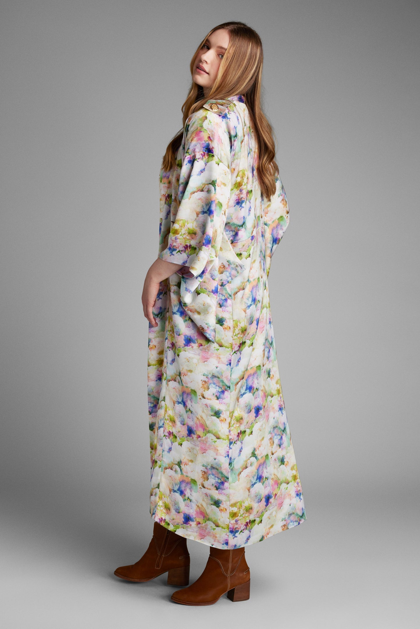 Back profile of woman modelling a long all over floral printed kimono duster made from recycled materials