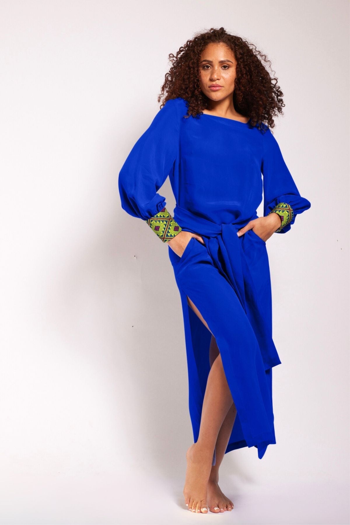 woman wearing a royal blue kaftan duster with embroidered sleeves made from recycled materials
