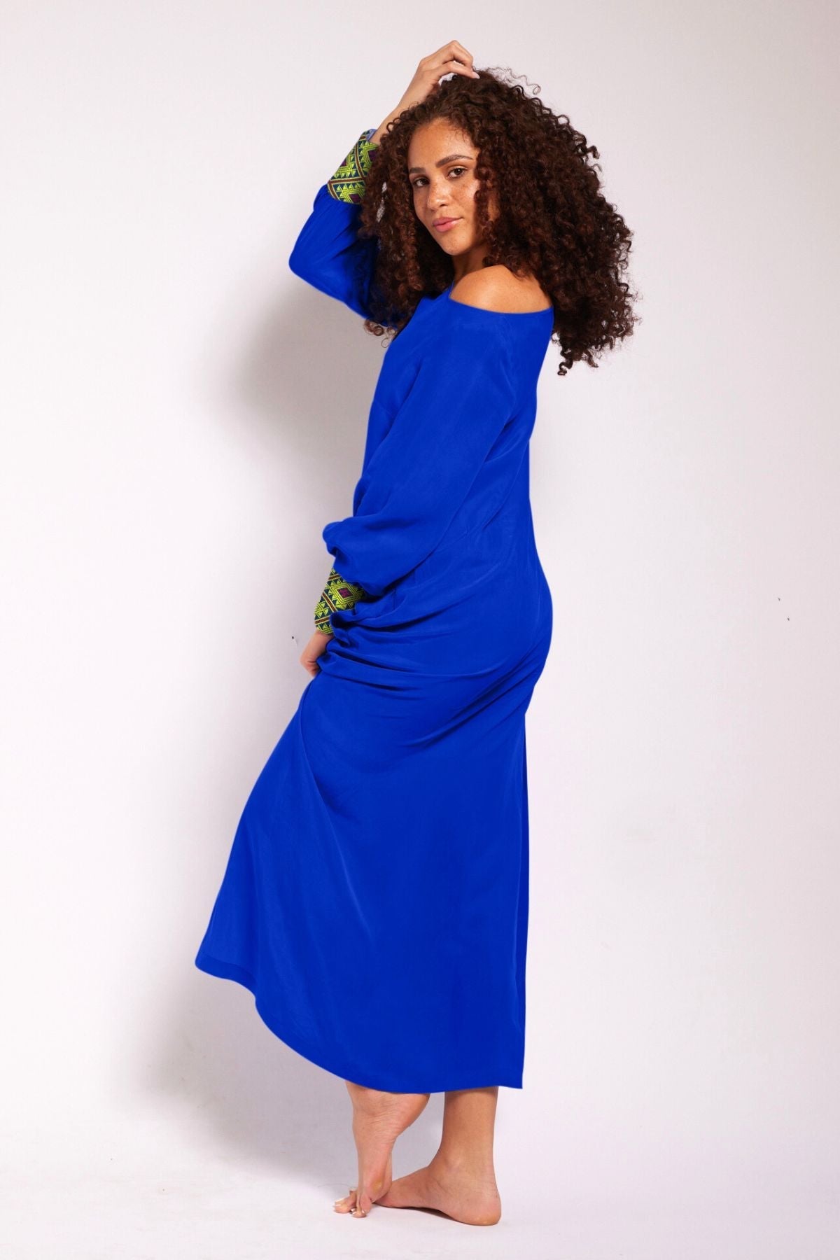 side view of woman wearing a royal blue kaftan duster with embroidered sleeves made from recycled materials 2
