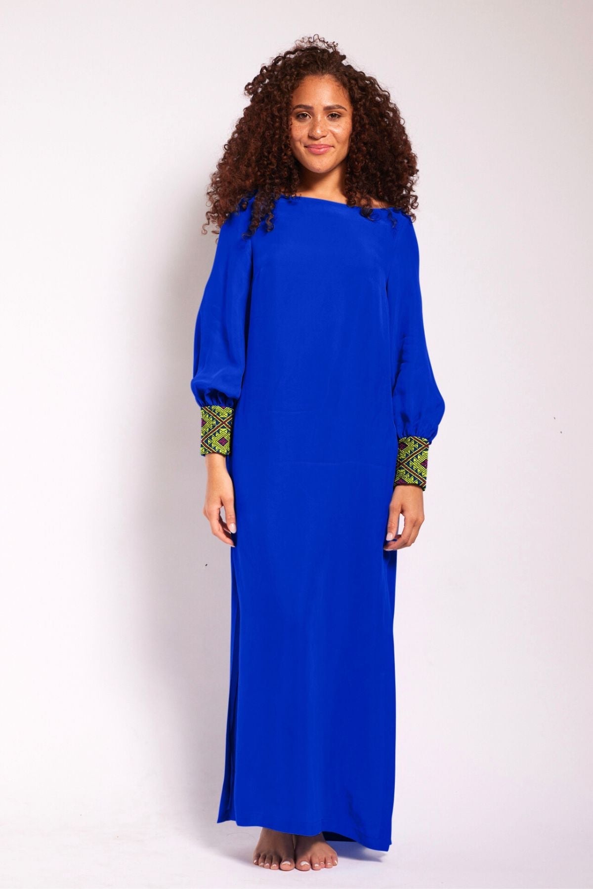 front view of woman wearing a royal blue kaftan duster with embroidered sleeves made from recycled materials 2