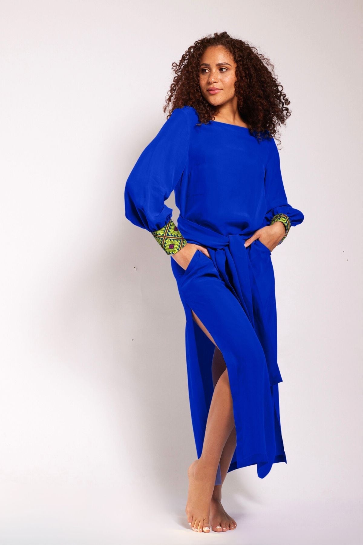 woman wearing a royal blue kaftan duster with embroidered sleeves made from recycled materials 3