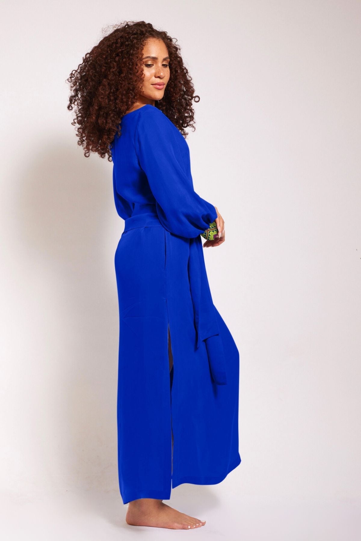 side view of woman wearing a royal blue kaftan duster with embroidered sleeves made from recycled materials