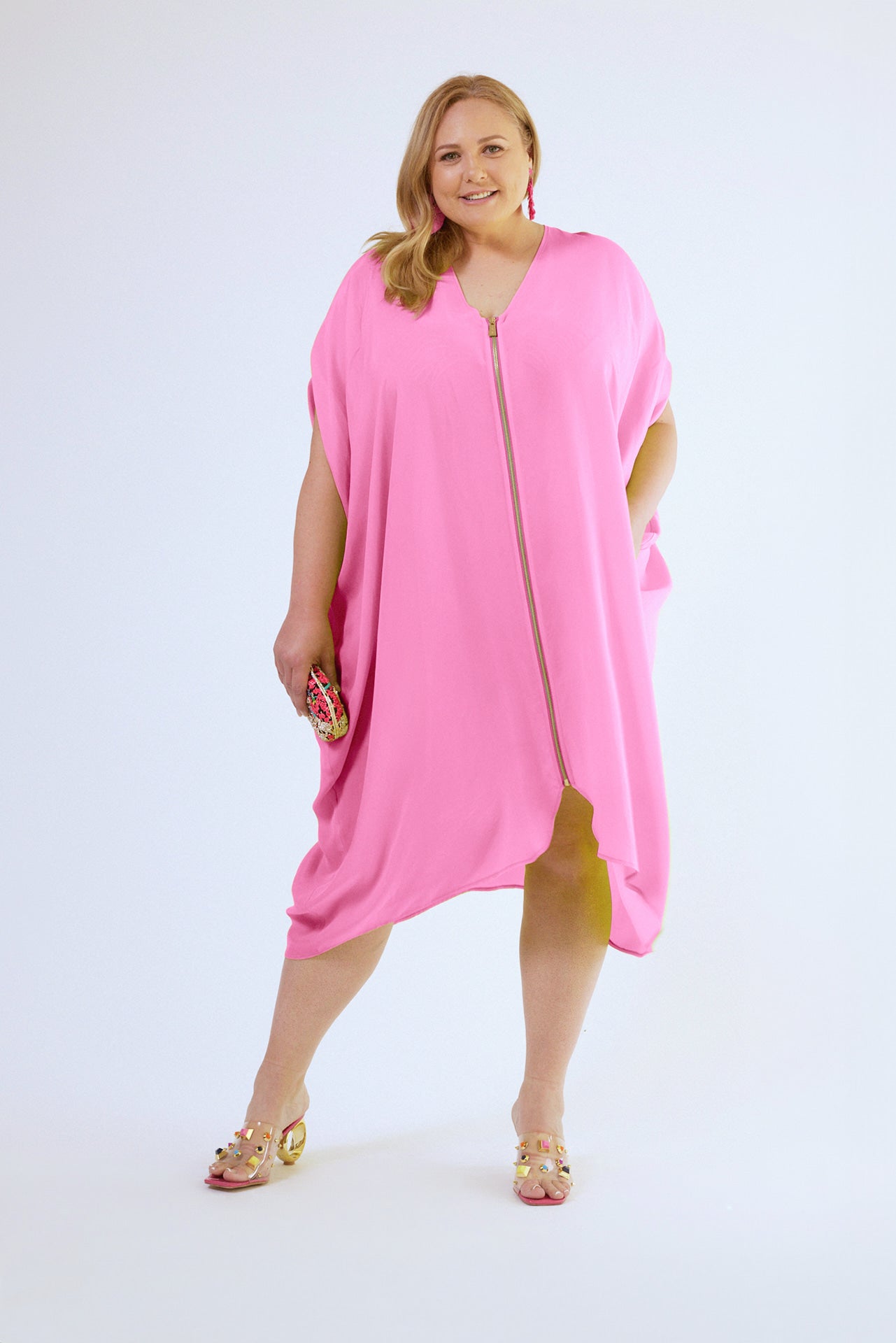 woman wearing bubble gum pink kaftan duster with front zipper with hand in her pocket 2