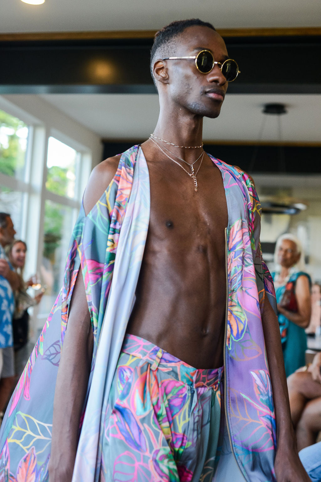 man modelling wearing all over tropical print kaftan duster with front zipper made from recycled materials 4